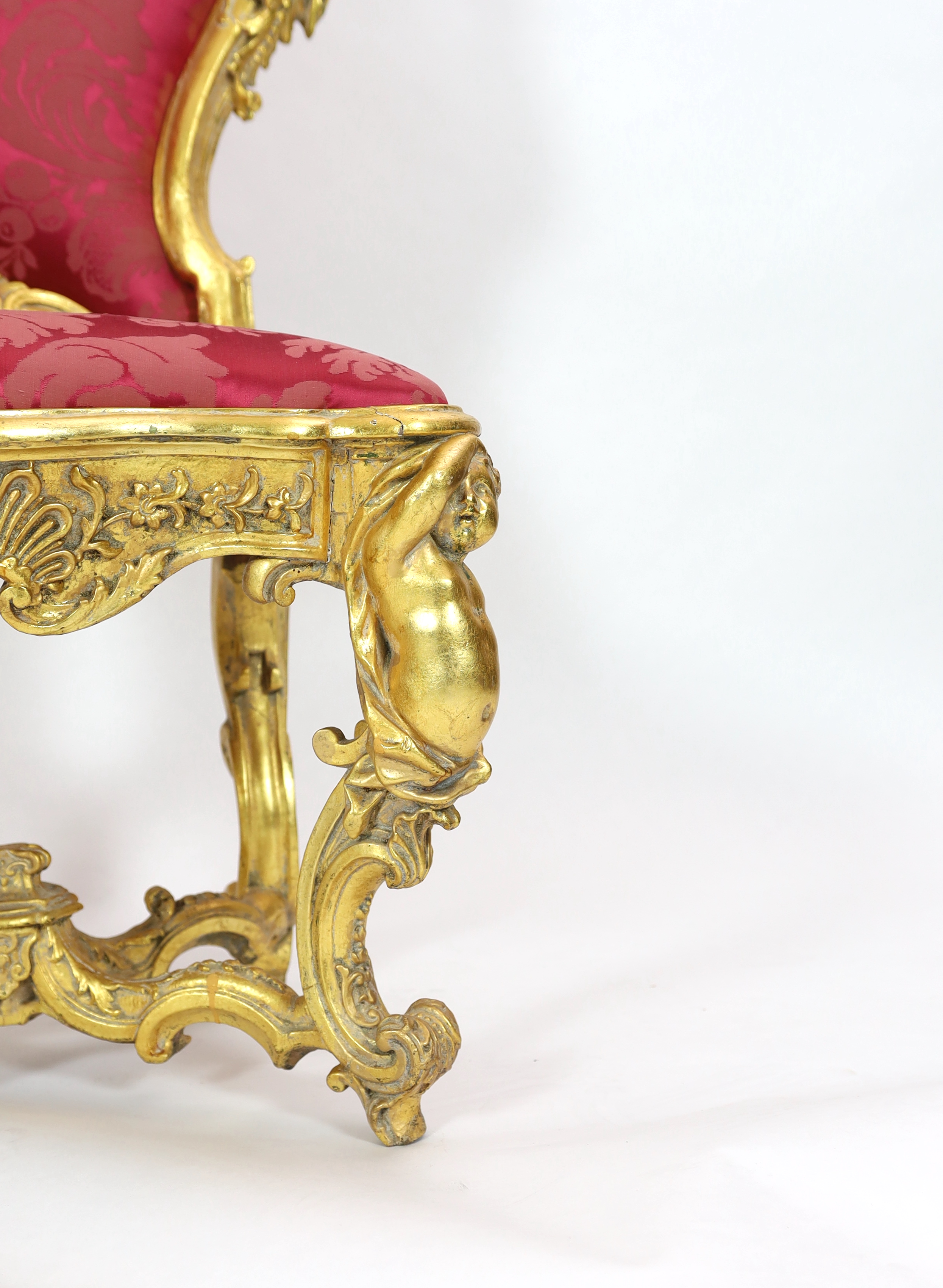 An important pair of late 18th century Venetian carved baroque giltwood throne chairs, the seats and backs upholstered in red floral silk. c.1770, 64cm wide, 55cm deep, 132cm high, Please note this lot attracts an additi